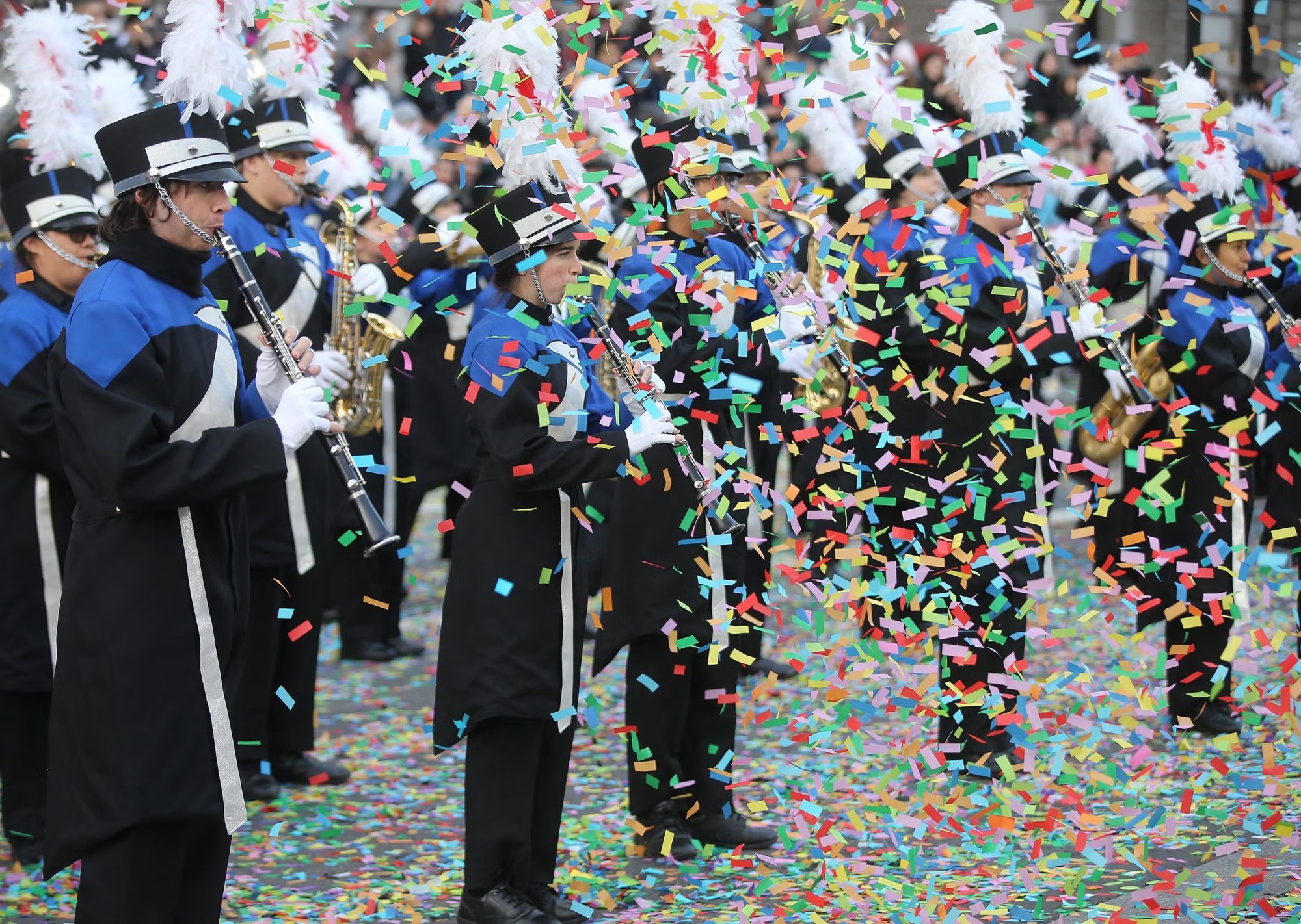 Marching band taking part in the London parade amid colourful confetti